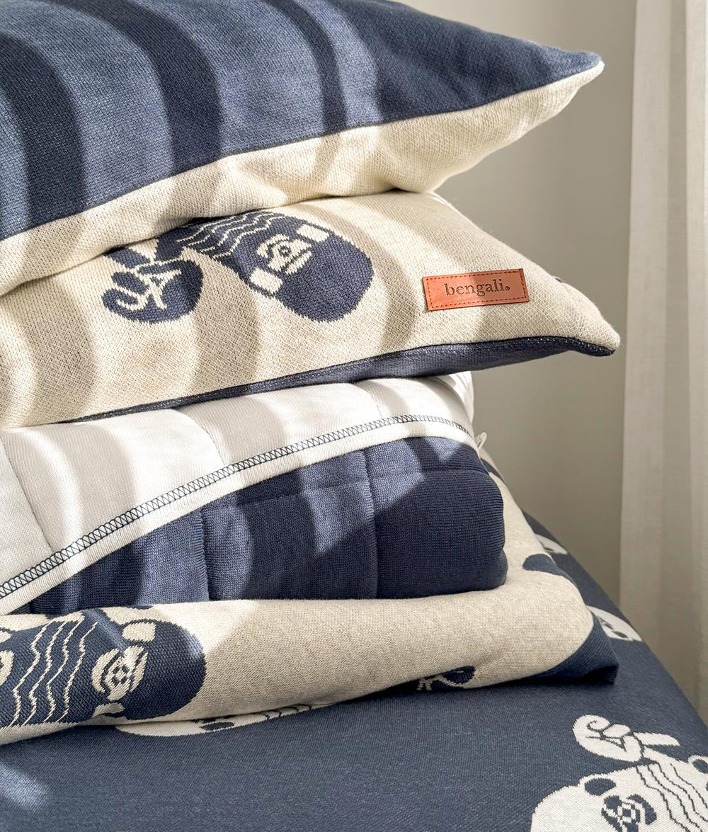 Stacked Skater Life pillowcases in soft jersey cotton, featuring navy and natural colourways with ivory skateboard and peace hand prints, styled on the matching navy fitted sheet.