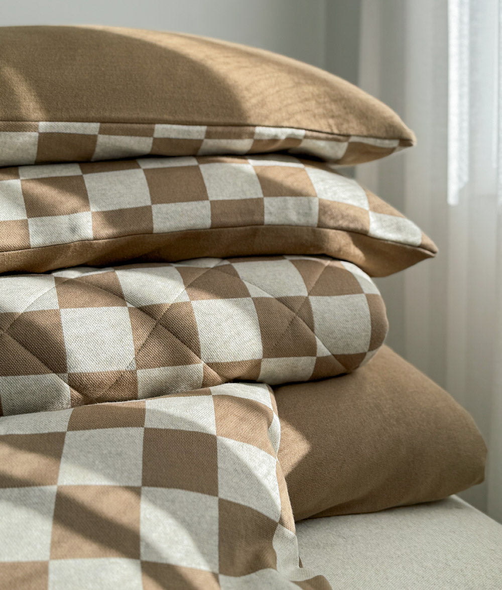 Khaki Gingham duvet cover styled with a plain khaki fitted sheet and neutral décor.